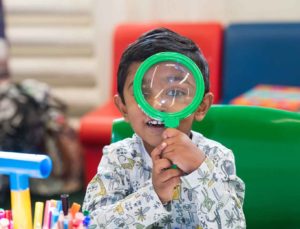 A boy uses a giant looking glass in the Harris library