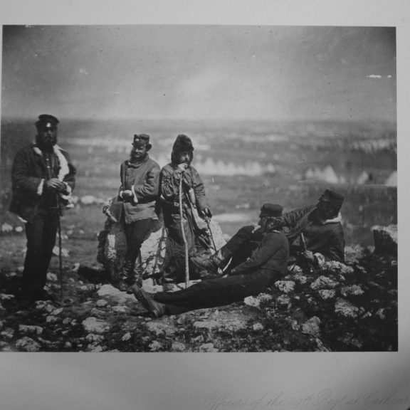 5 officers relaxing on rubble. A candid photograph.