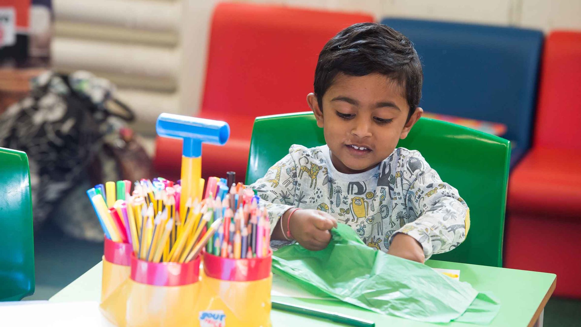 small boy doing arts and crafts at a table