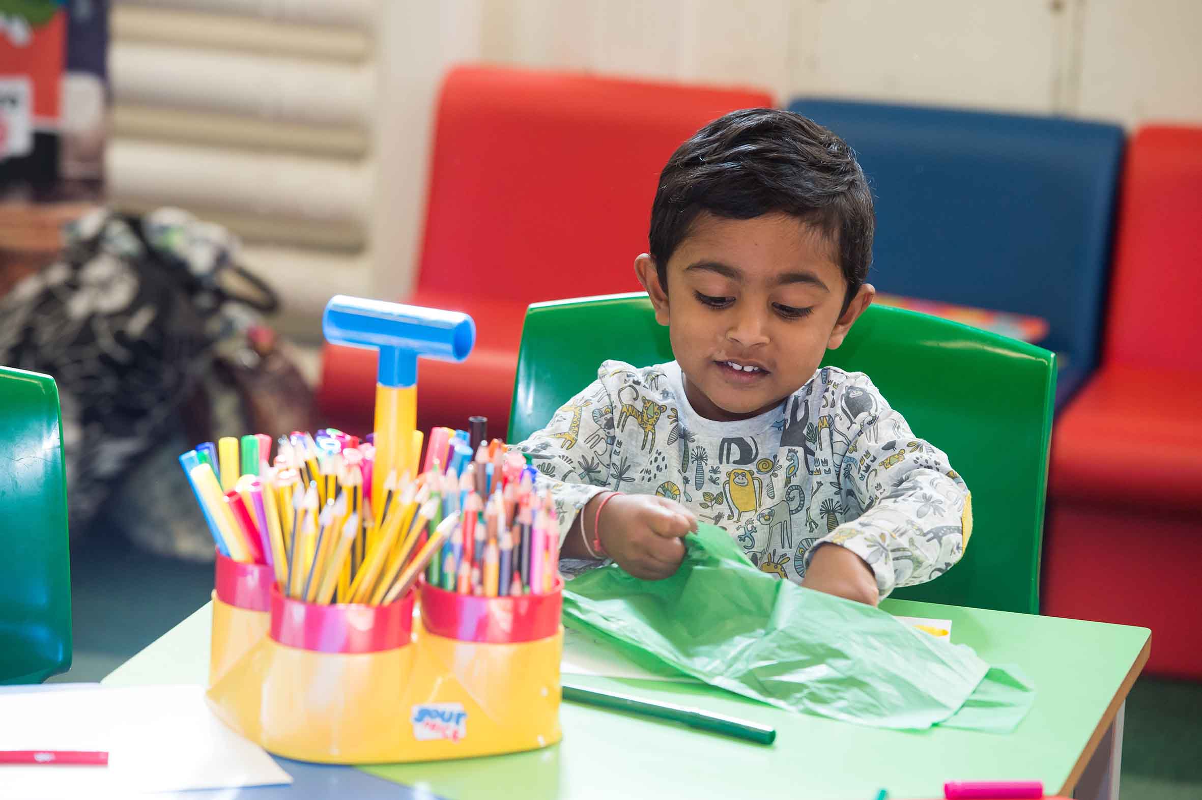 small boy doing arts and crafts at a table