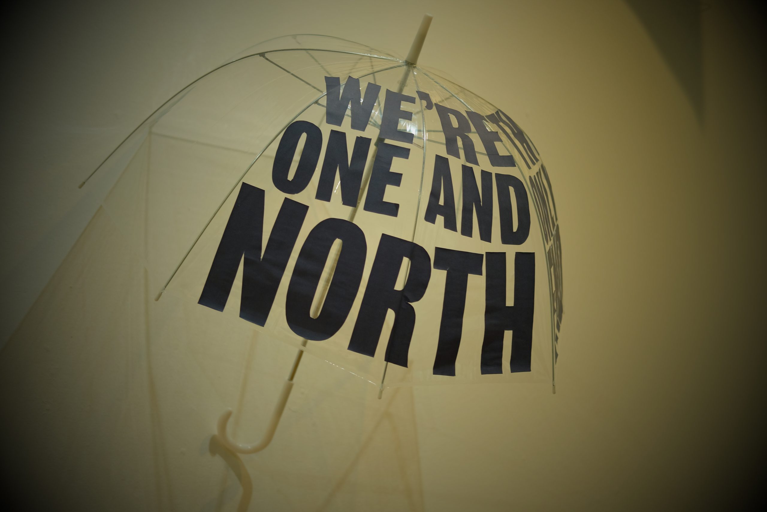 Umbrella with the words 'We're one and North' on it 