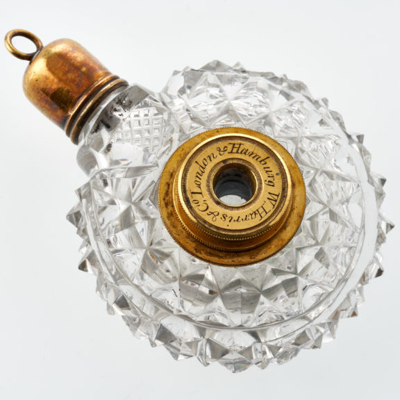 Clear cut glass circular scent bottle with novelty tiny telescope in the centre