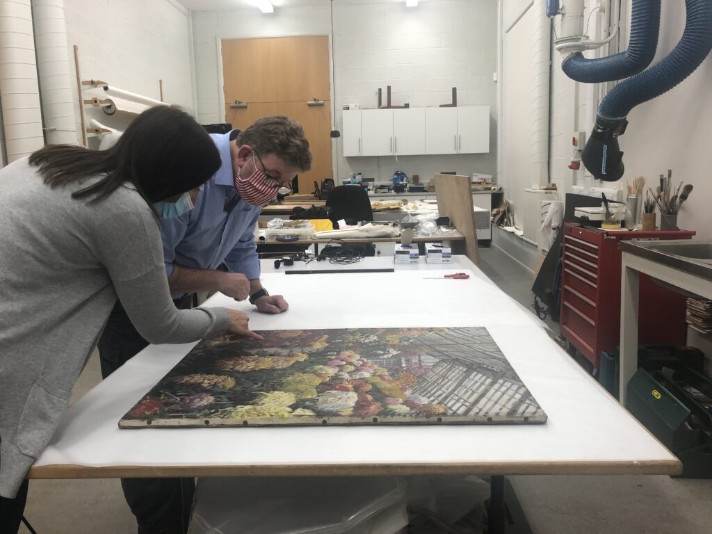 One of the Harris' curators at Lancashire Conservation Studio discussing a paintings restoration needs