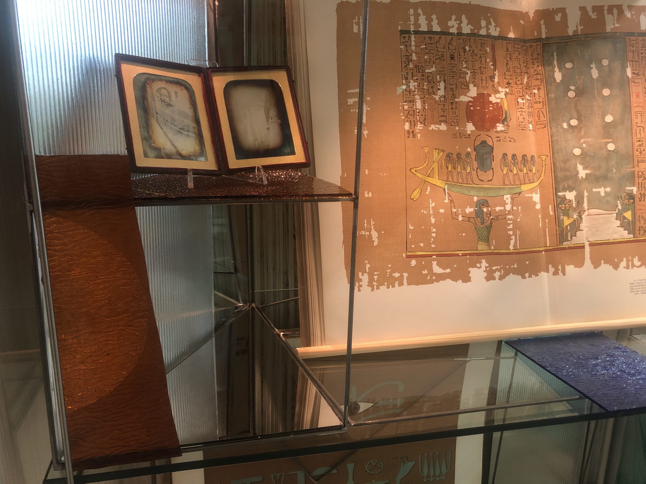 close up shot of book case with precious objects in it such as the daguerreotype and atlas portfolio.