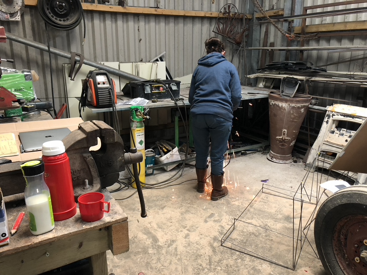 Lady in a yard with tools welding metal