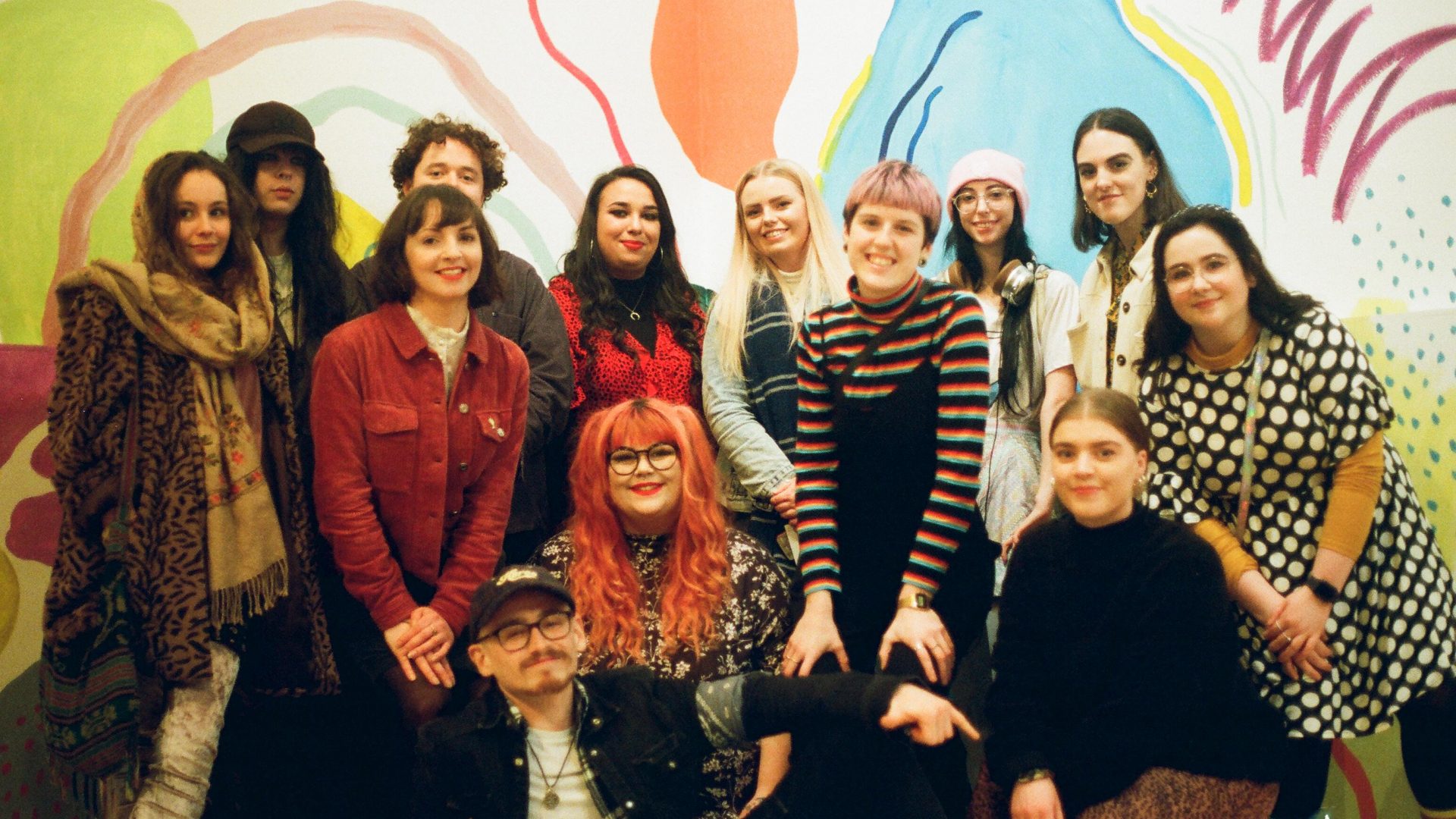 A group of young people in front of a contemporary artwork