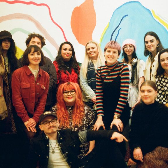 A group of young people in front of a contemporary artwork