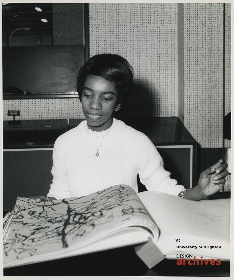 Lady looking through large design books 