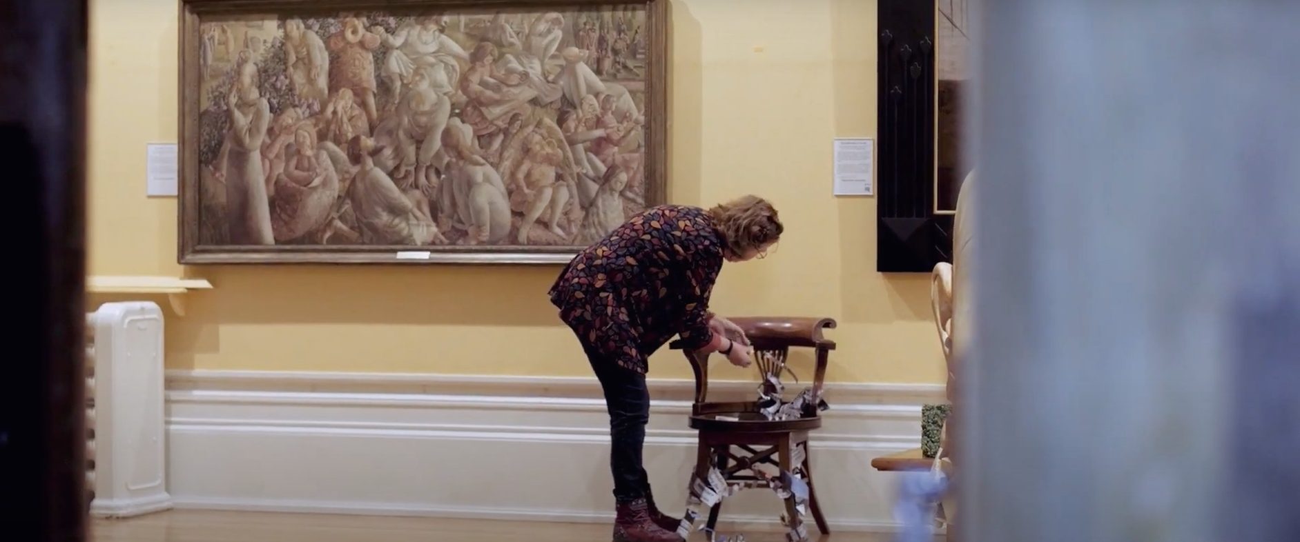 Artist attaching artwork to chair