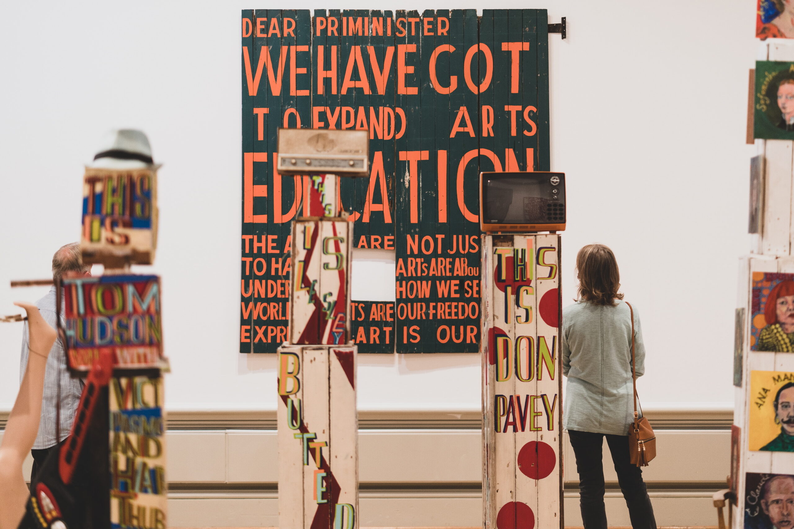 A person looking at the colourful artworks in the Bob and Roberta Smith exhibition