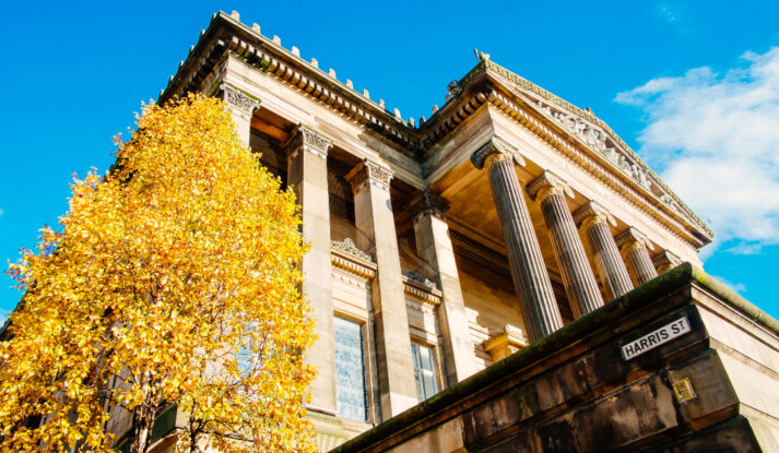 Outside Harris building with autumn tree in foreground.