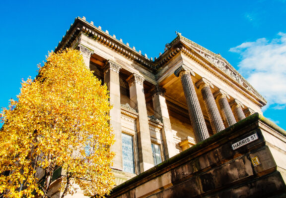 Outside Harris building with autumn tree in foreground.