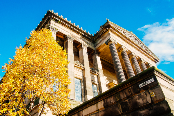 Outside Harris building with autumn tree in foreground.