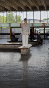 Image of artist Nicola Woodham wearing a white etextile sound suit with a large etextile pom pom on their head