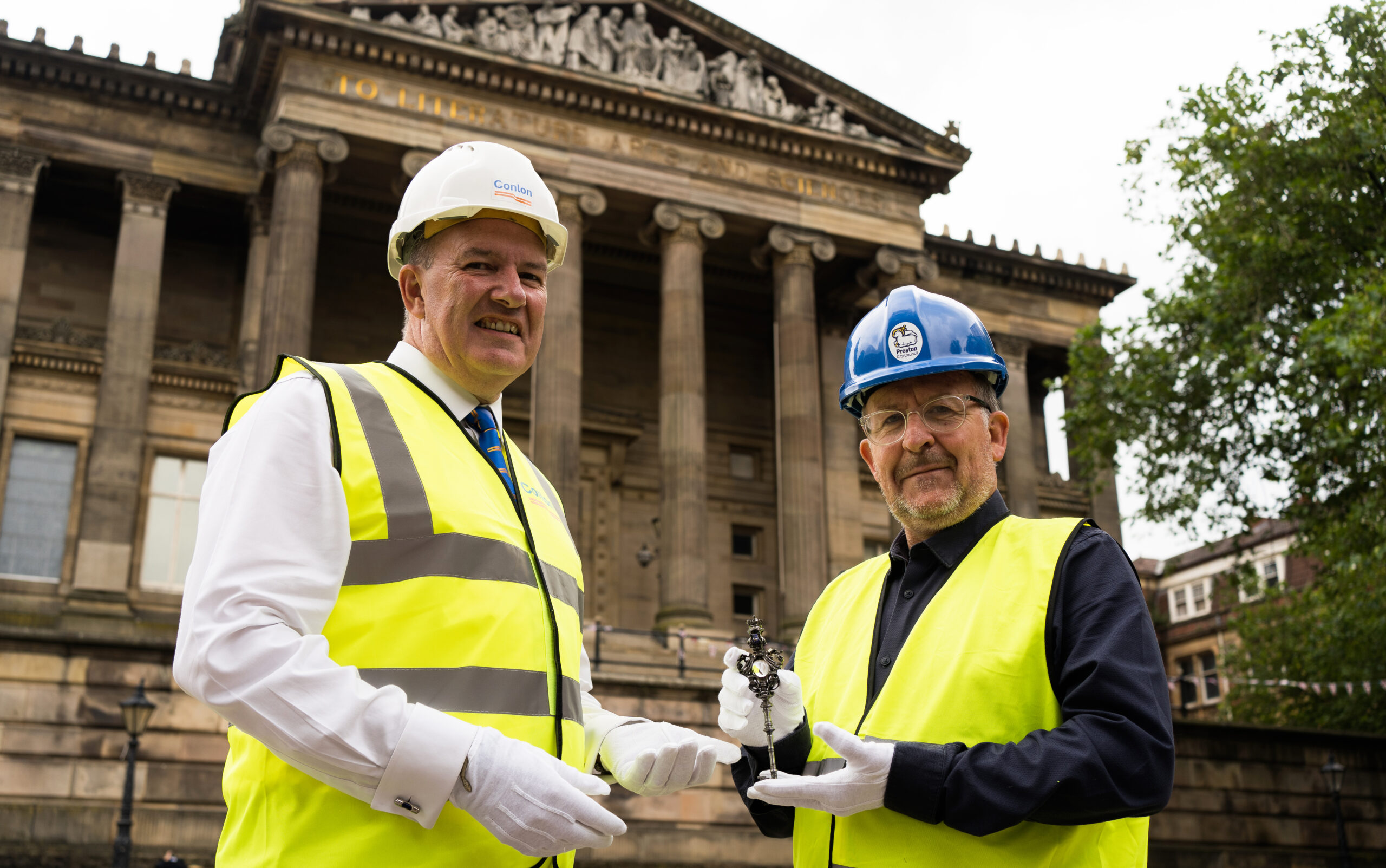 Image of Councillor Peter Kelly handing over the ceremonial Harris key to Michael Conlon outside the front of the Harris building.