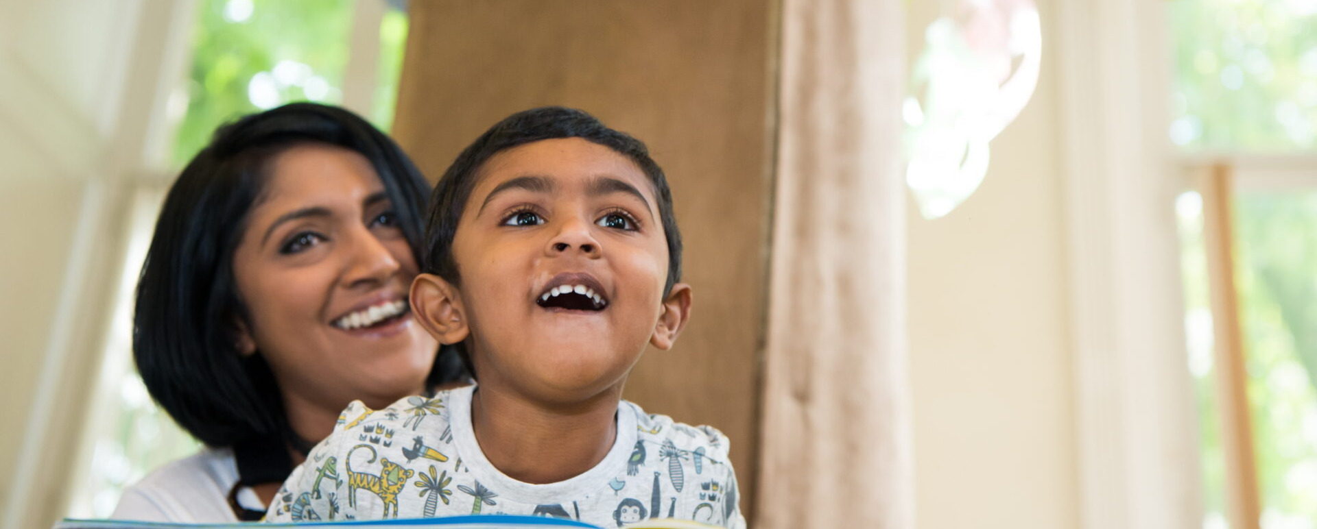 Image of a mother and son looking at a hanging mobile in the Children's Area