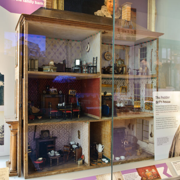 Image of the Doll House behind glass in the Harris' Discover Preston Museum