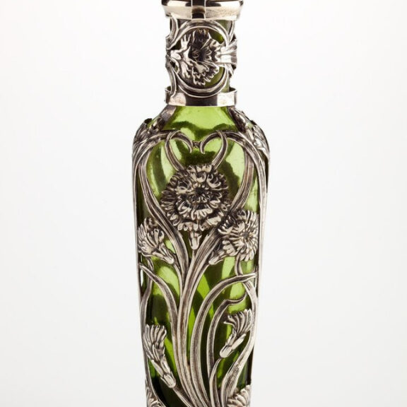 Image fo a green decorative scent bottle with ornate silver detailing.