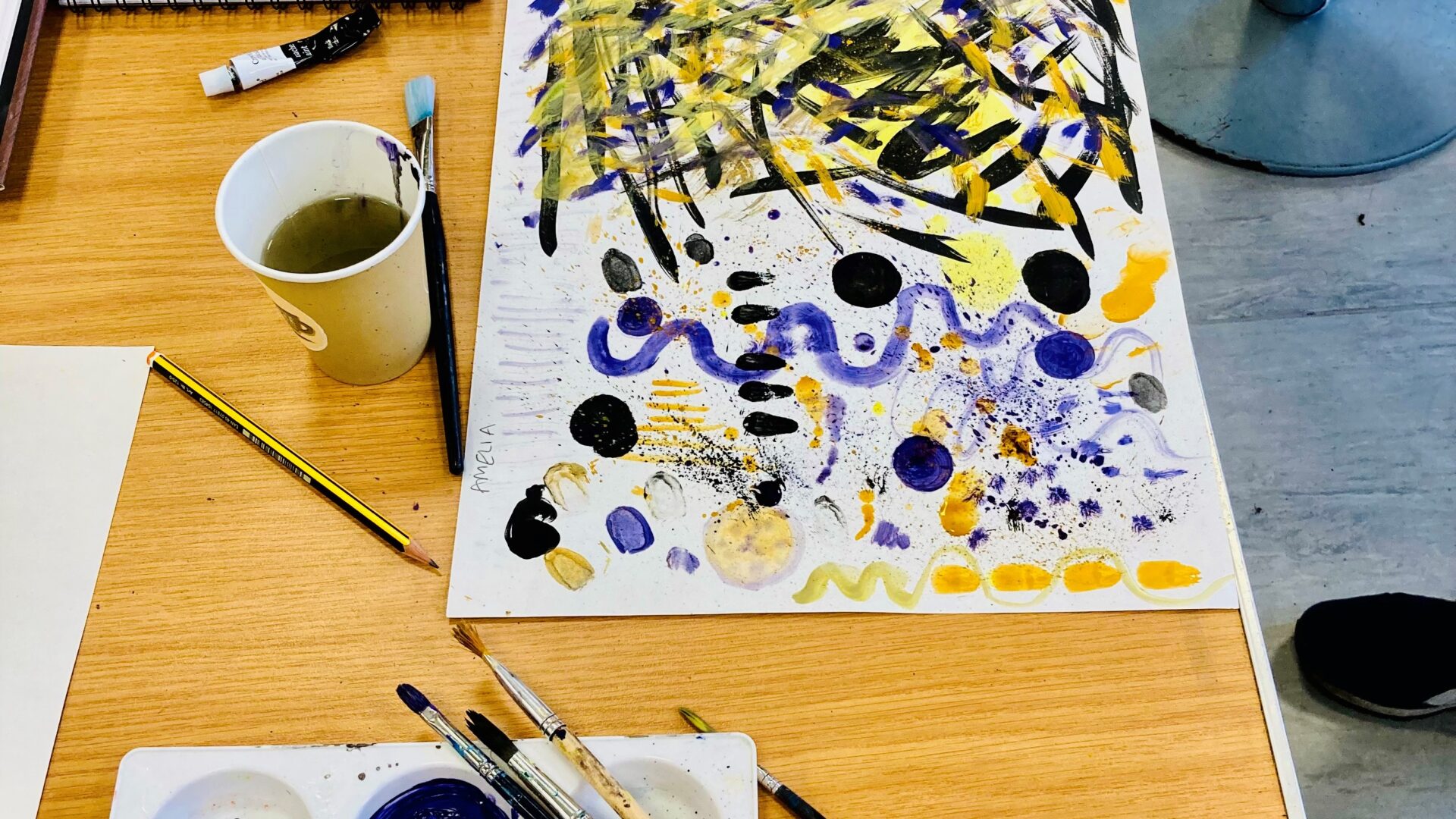 Image of artwork and paints on a table