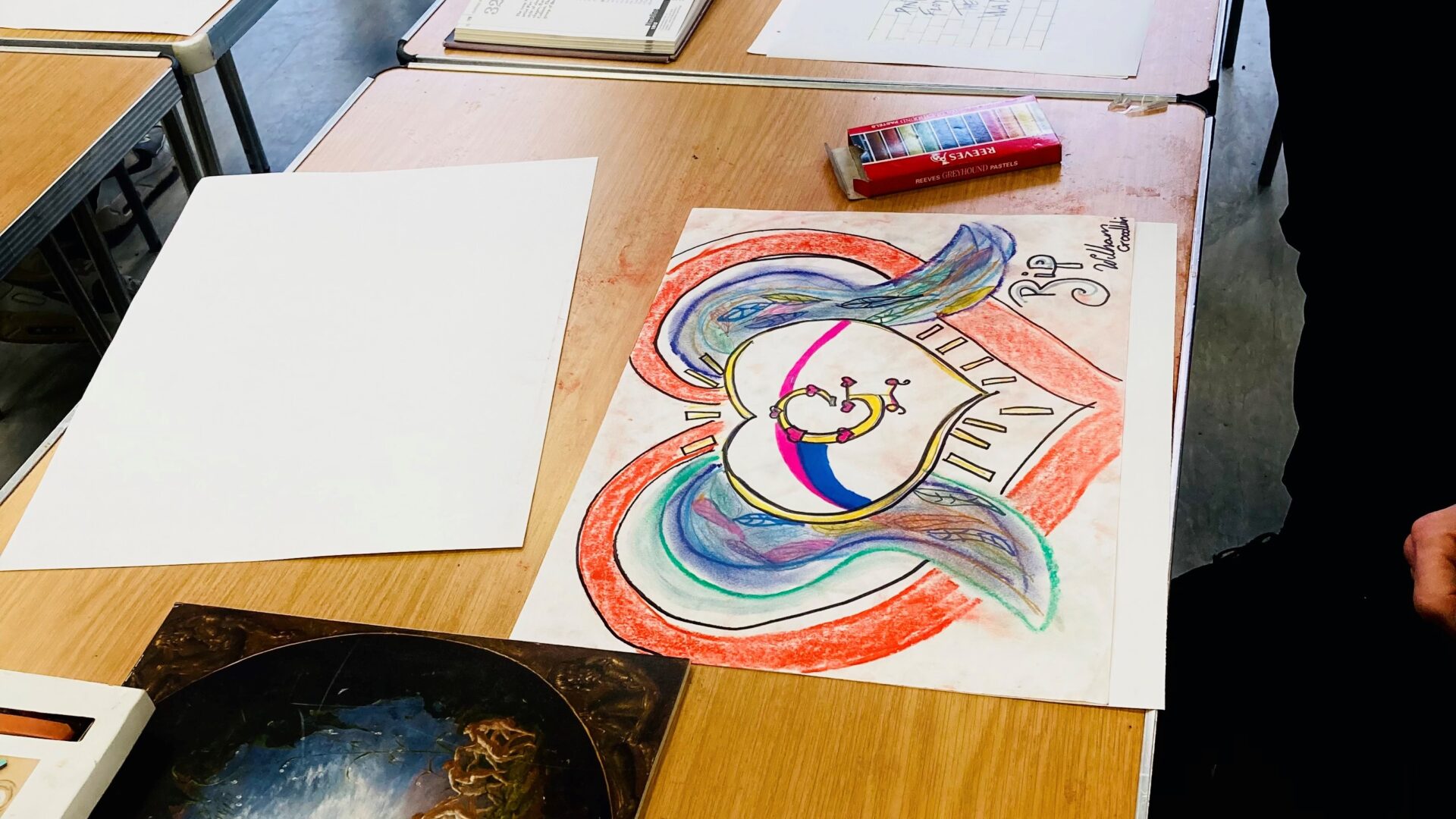 Image of artwork and paints on a table