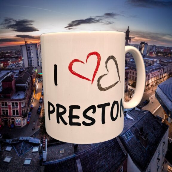 A white ceramic mug with a birds eye view of Preston in the background.