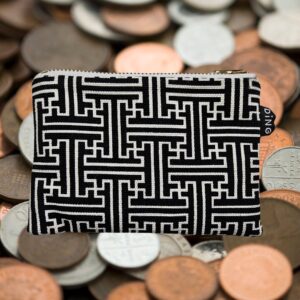 A black and white purse with coins in the background.