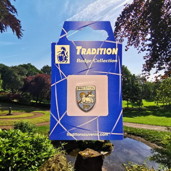 A blue and white crest of Preston badge with Avenham park in the background.