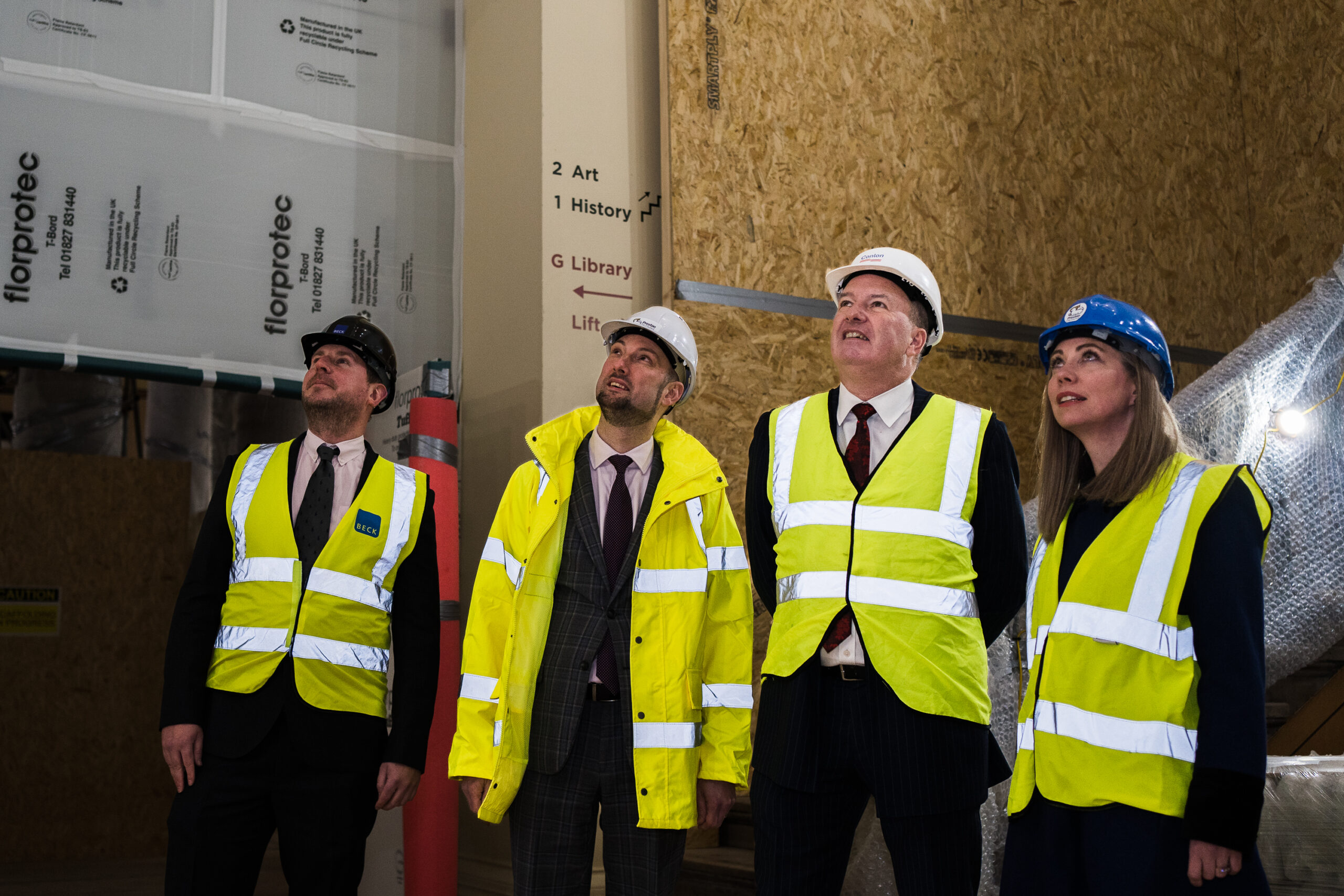 Image of four people in hi-vis and branded helmets.