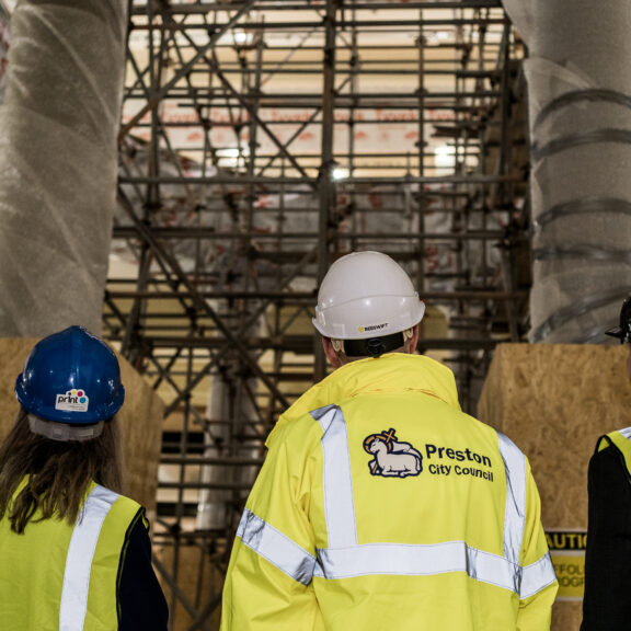 Image of four people in hi-vis and branded helments.