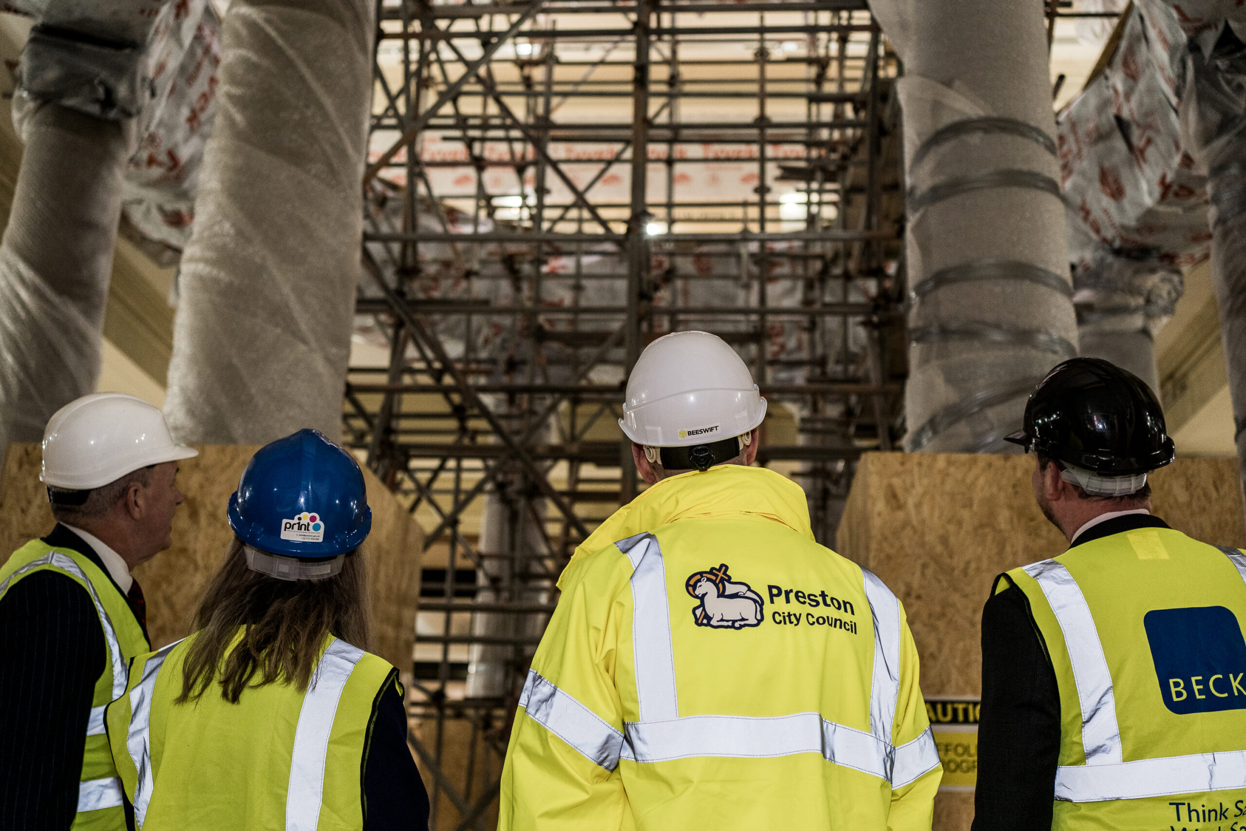 Image of four people in hi-vis and branded helments.