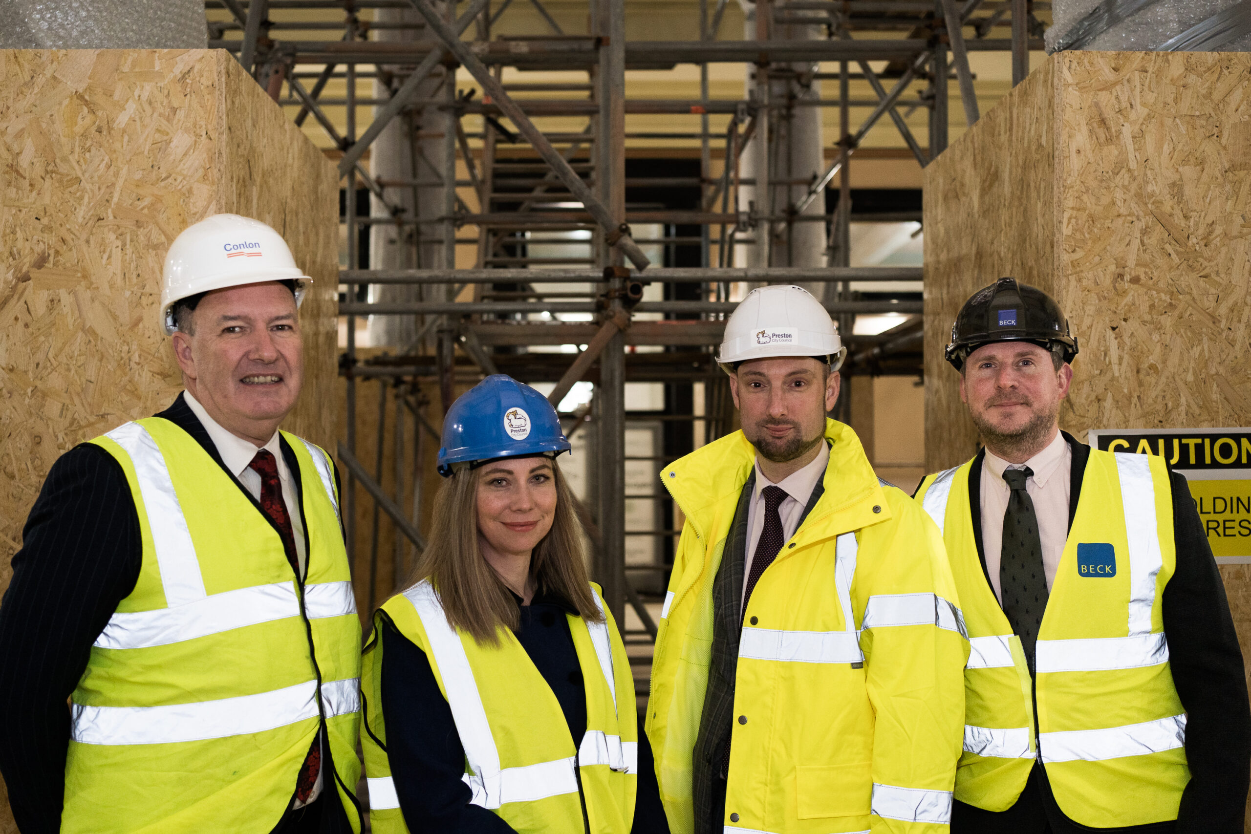 Image of four people in hi-vis and branded helmets.