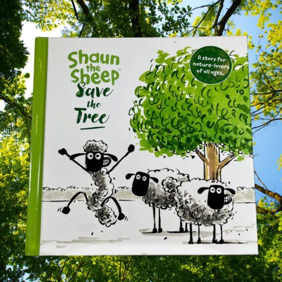 Front cover of a Shaun the Sheep book with trees in the background.