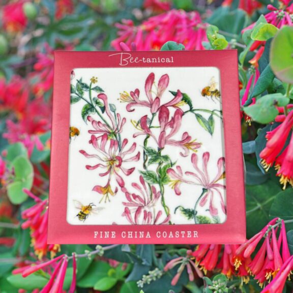 A ceramic coaster decorated with honeysuckles.