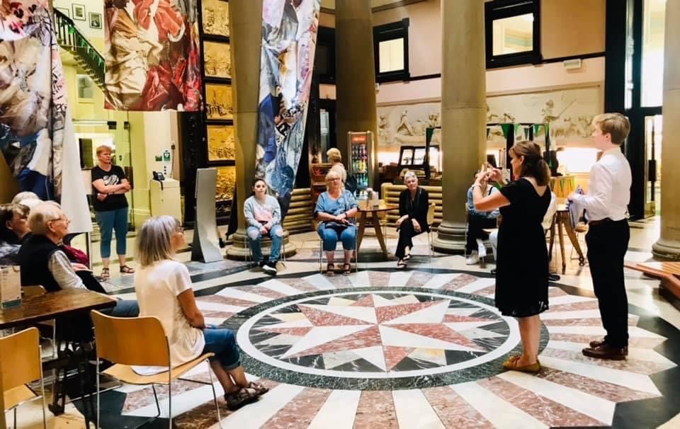 An image of a group of people gathered at a British Sign Language session.