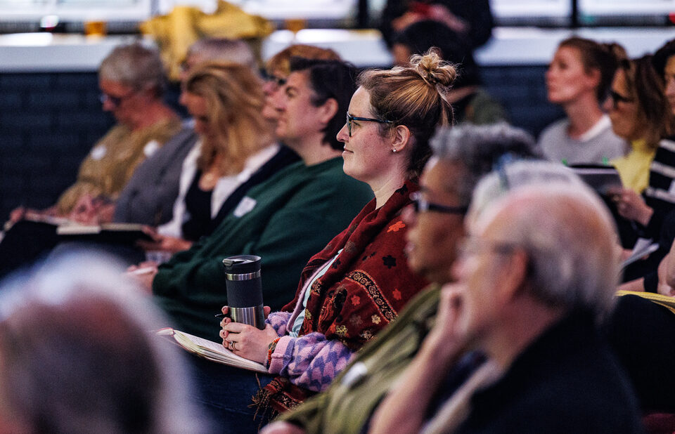 A row of people sitting down at an event.