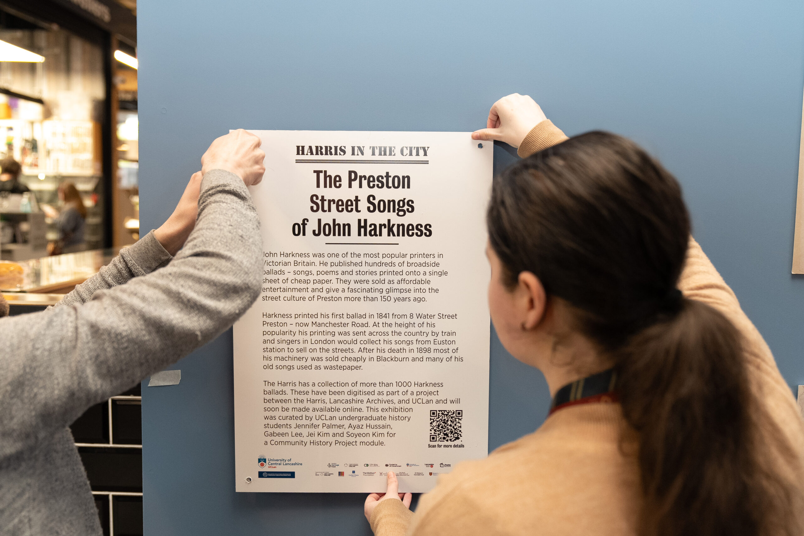 An image of two people holding up a Preston Street Songs poster.