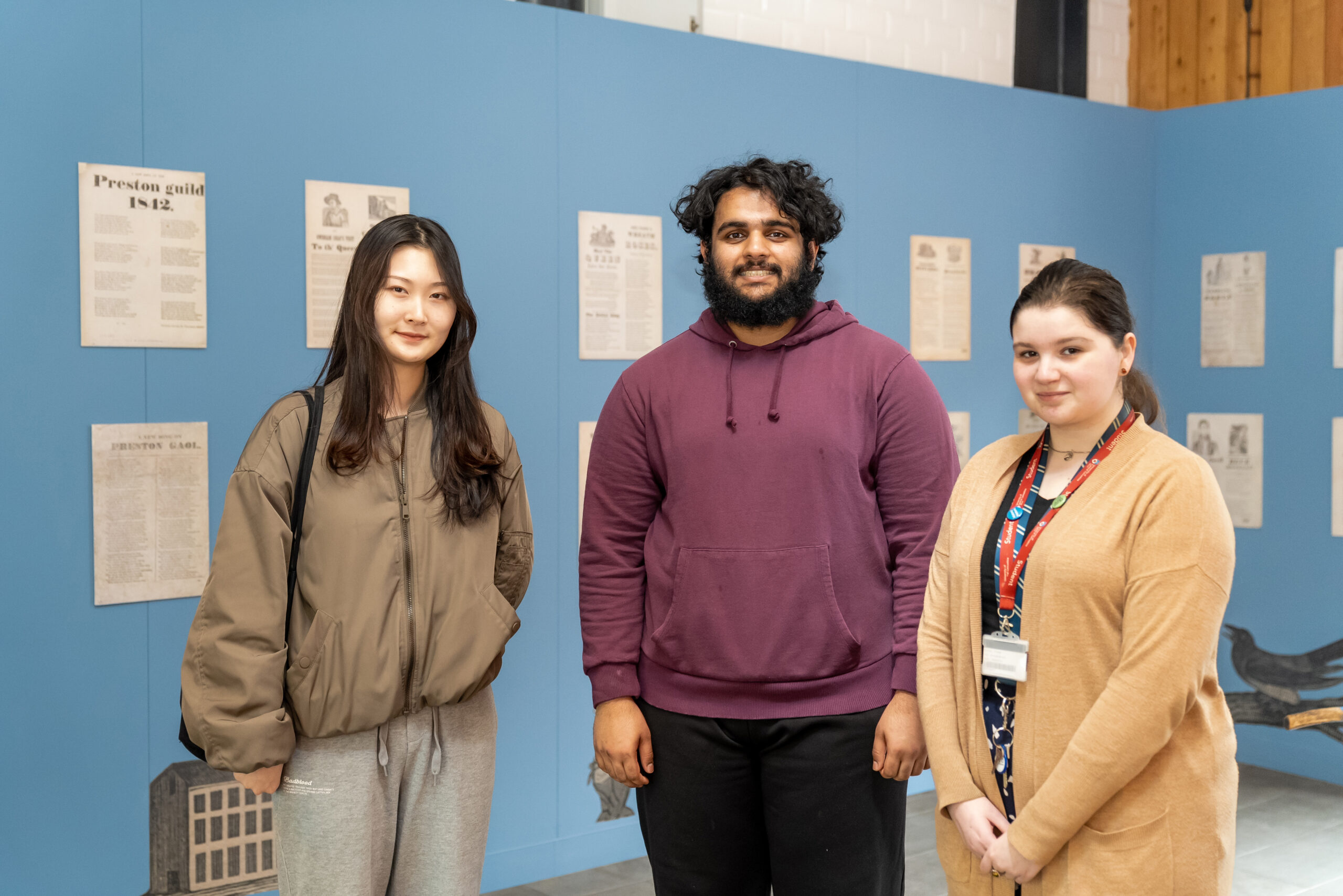 A group of people standing in front of the Preston Street Songs exhibition.