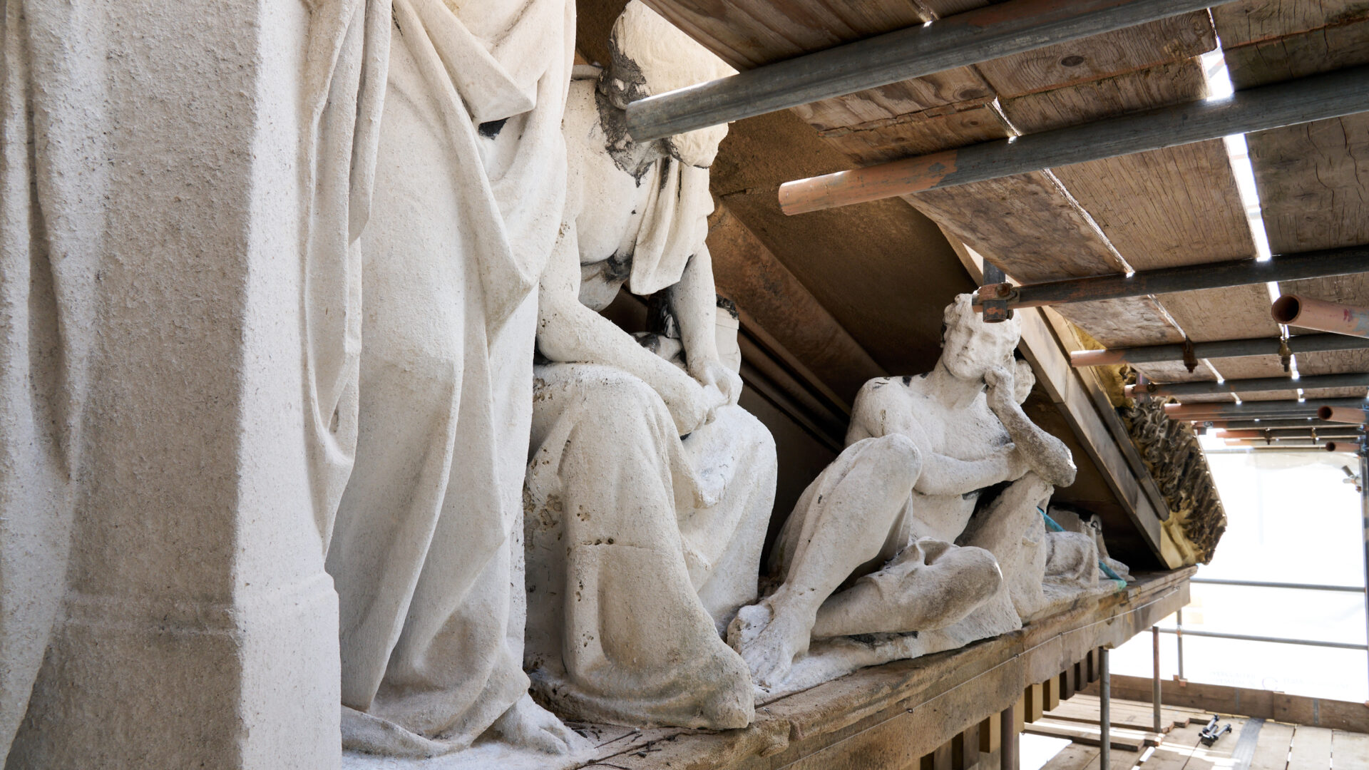 An image of sculptures behind scaffolding.