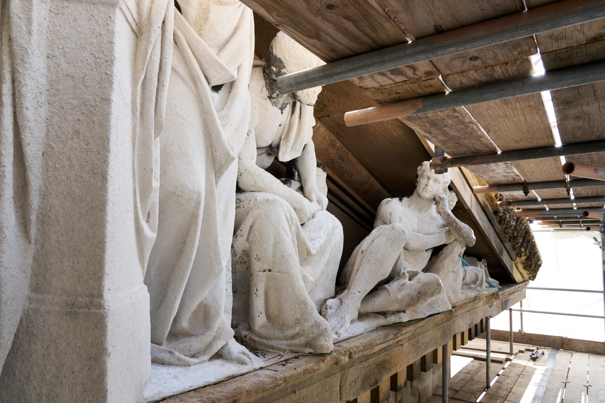 An image of sculptures behind scaffolding.