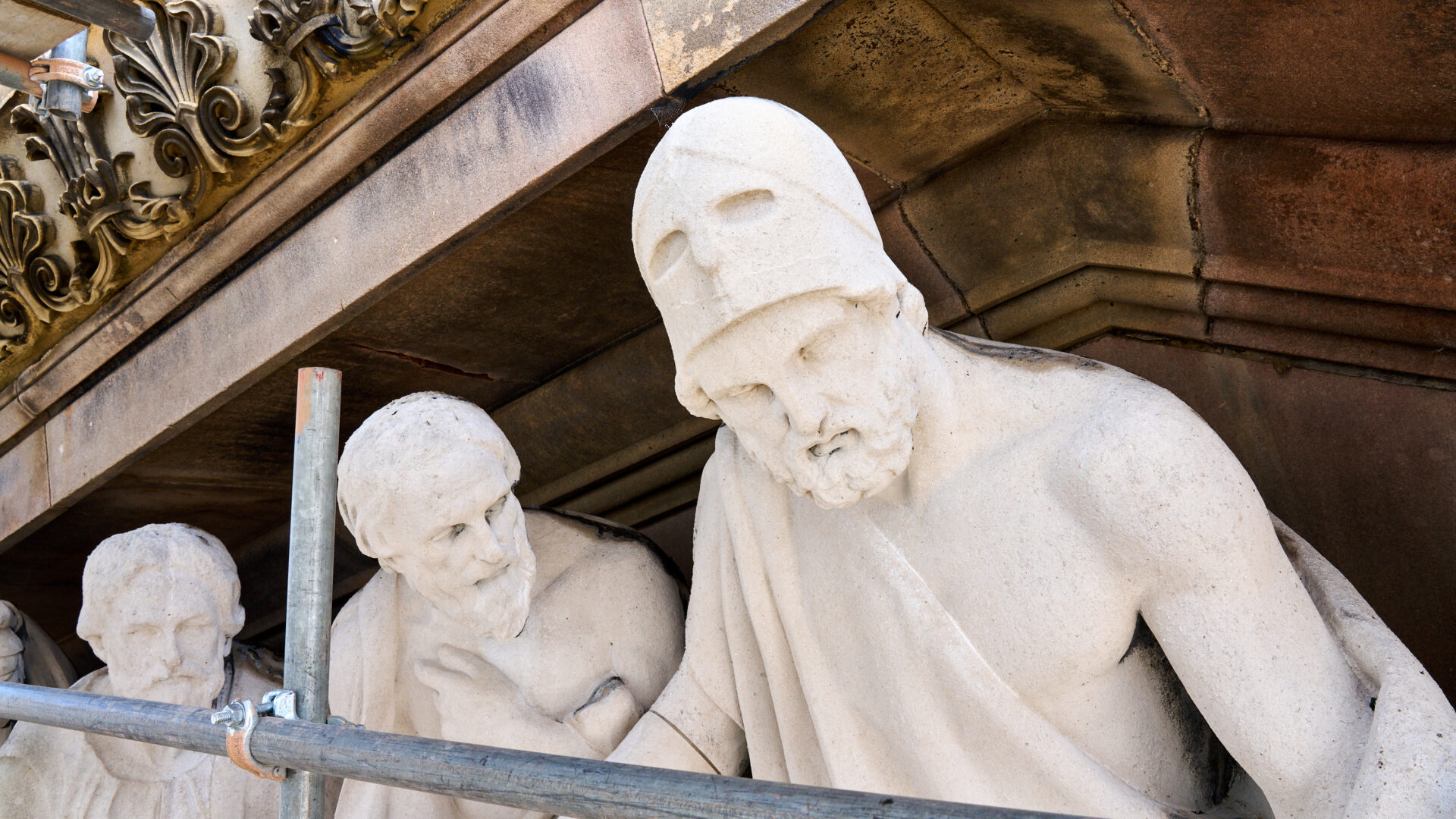 An image of sculptures behind scaffolding,