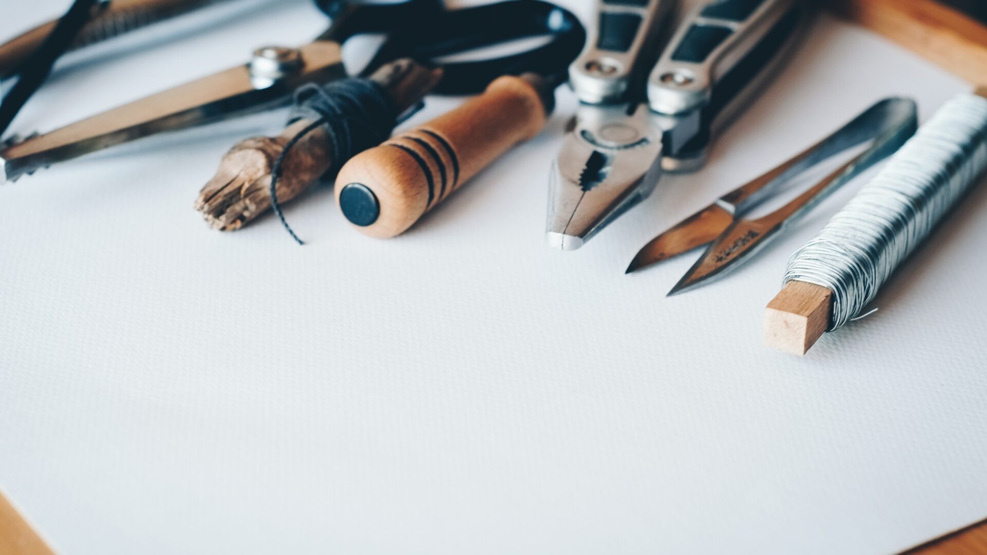 A number of tools rest on top of a blank sheet of paper.