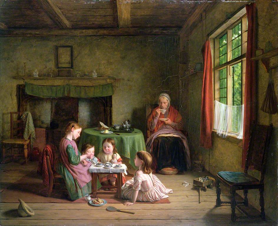 A family sit around a small table on a wooden floor for a tea party.