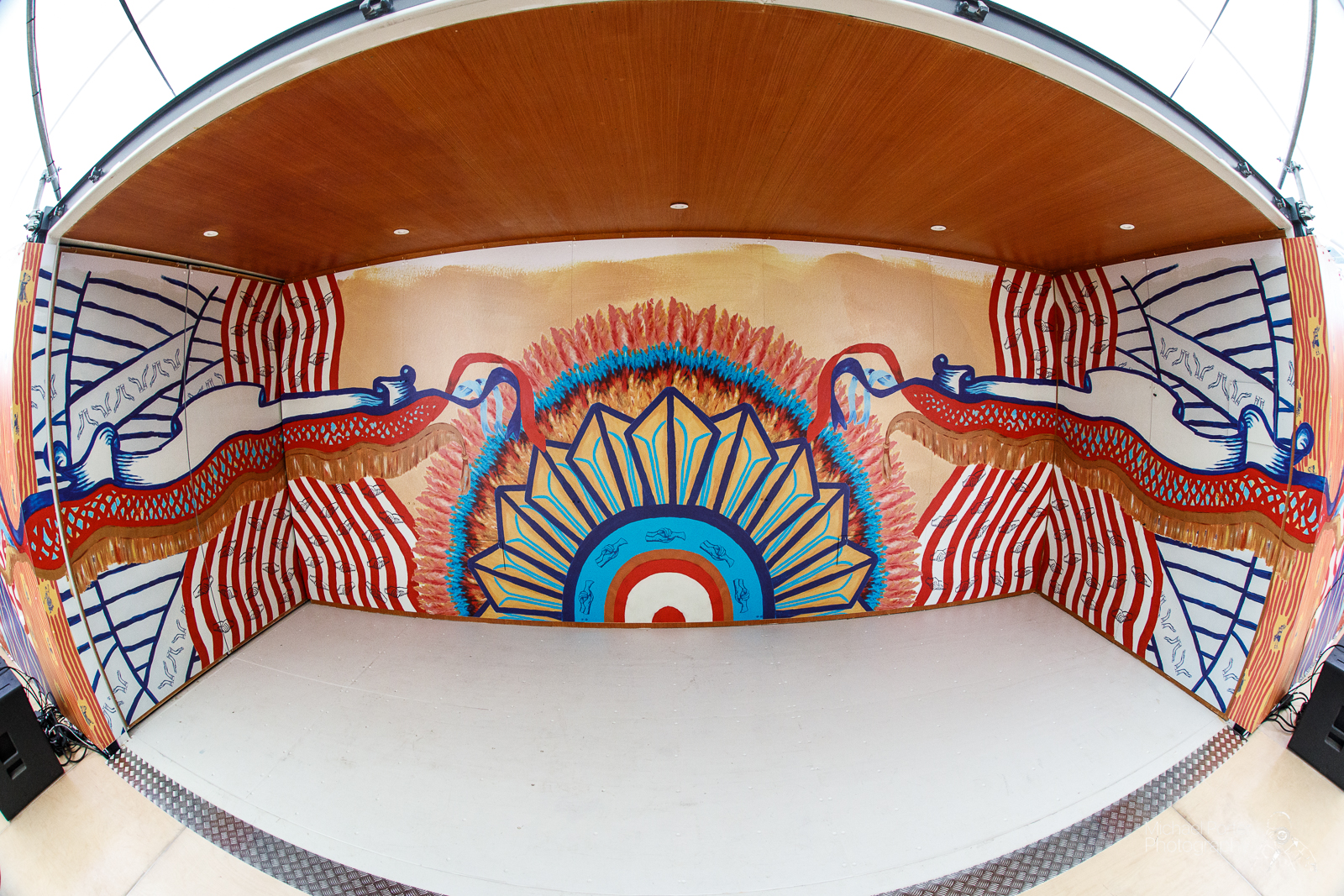 The inside of the mobile event tent. The walls are painted with colourful patterns.