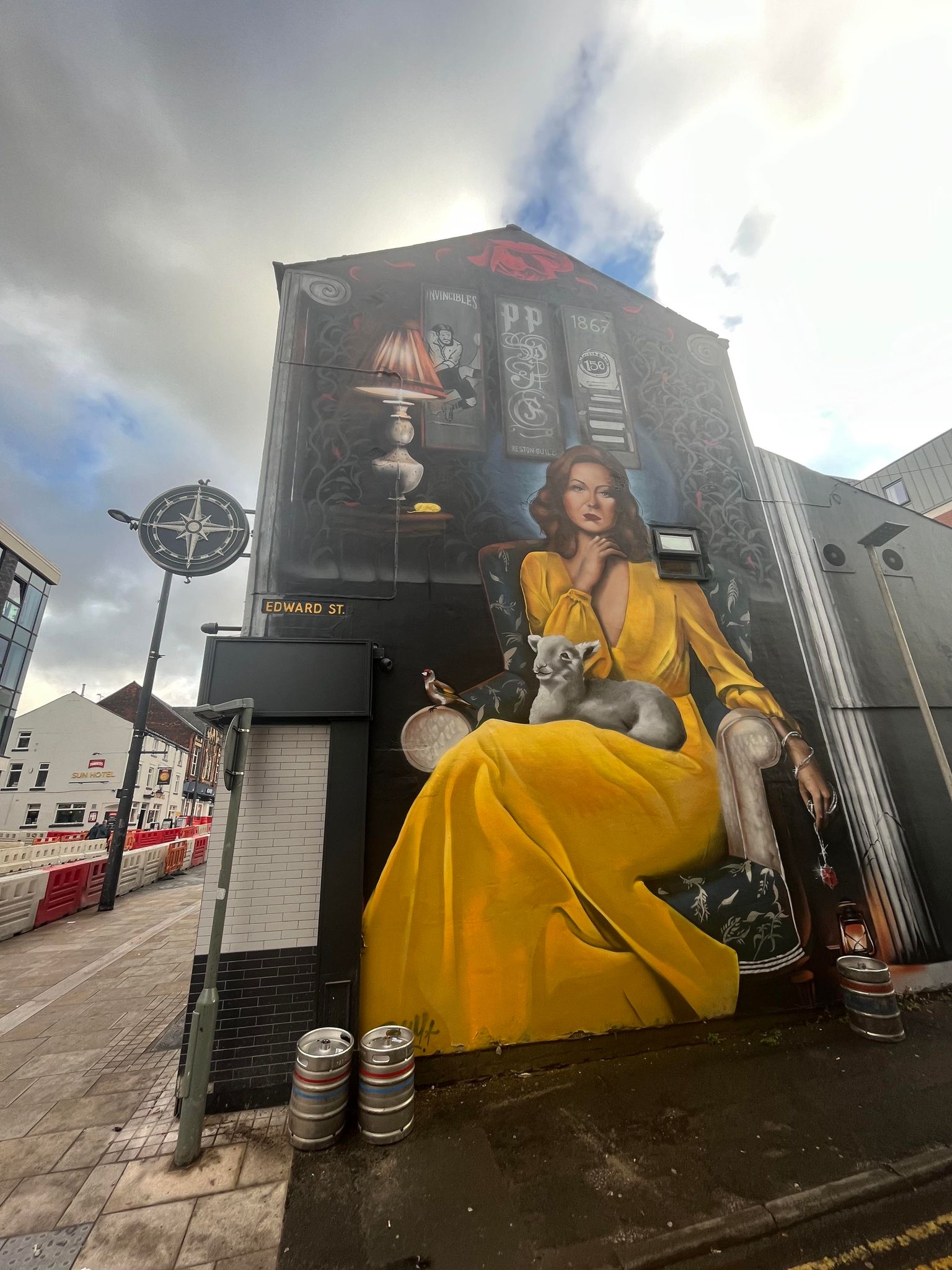 Image of a large street artwork of a woman in a yellow dress