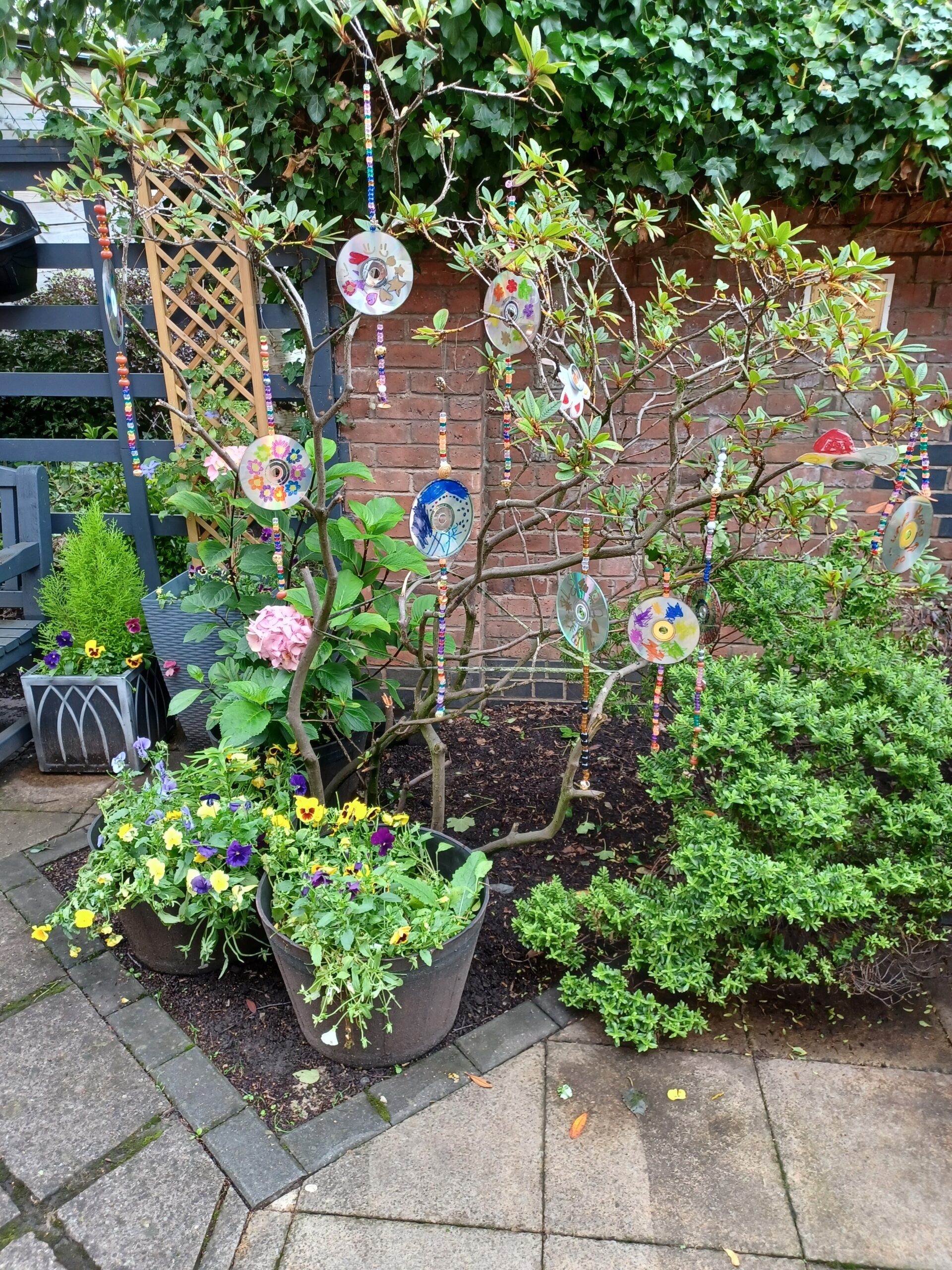 Painted CDs hanging from small trees.