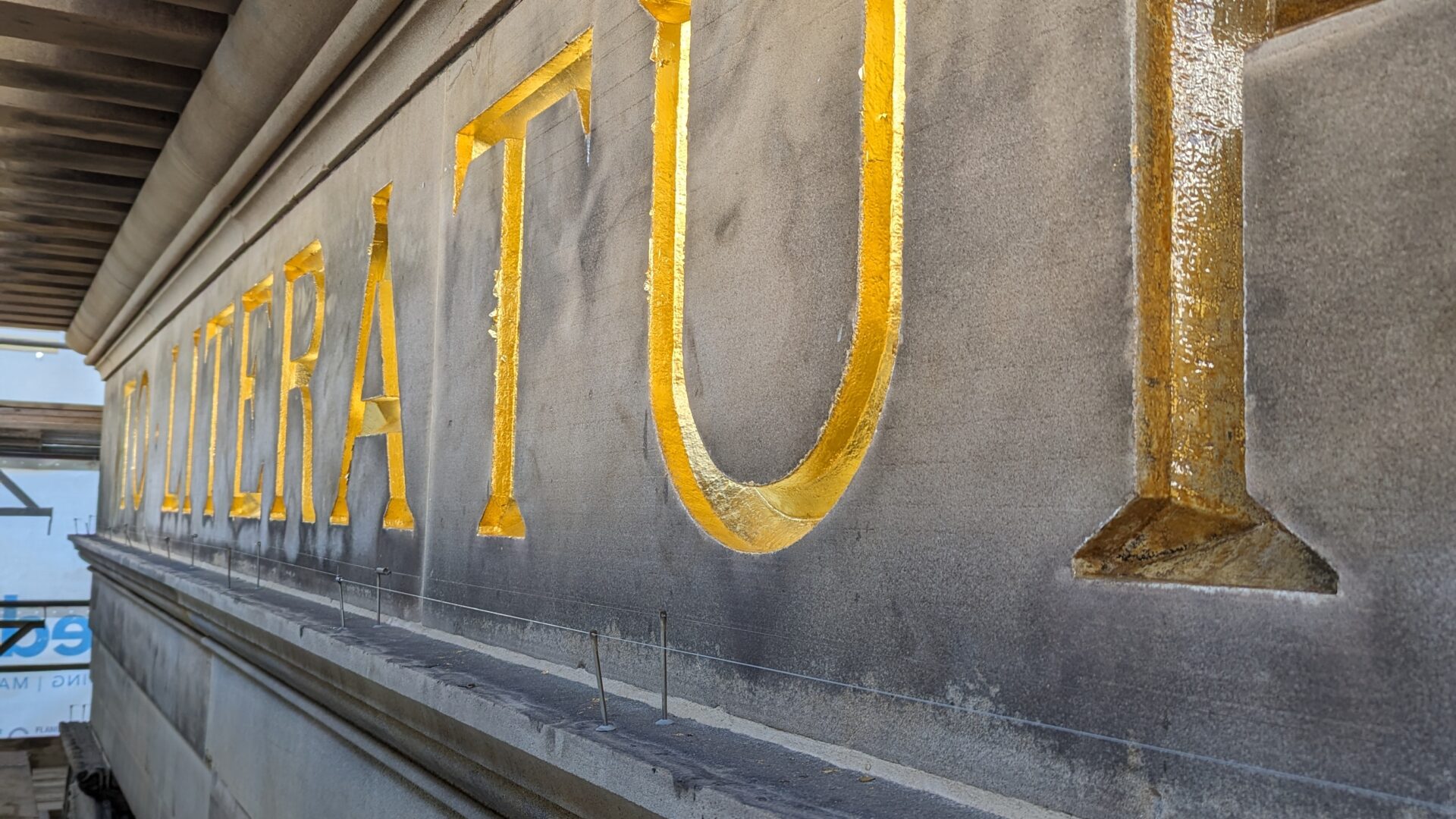 A close up of the gold lettering under the pediment.