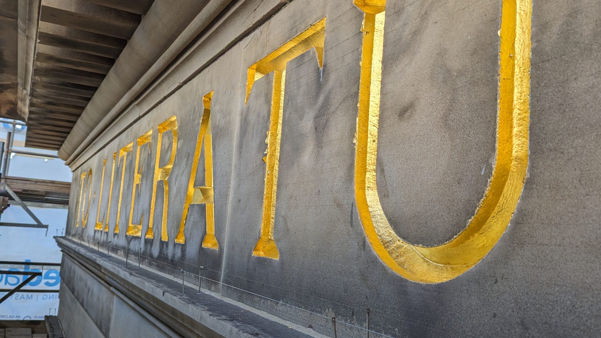 A close up of the gold lettering under the pediment.