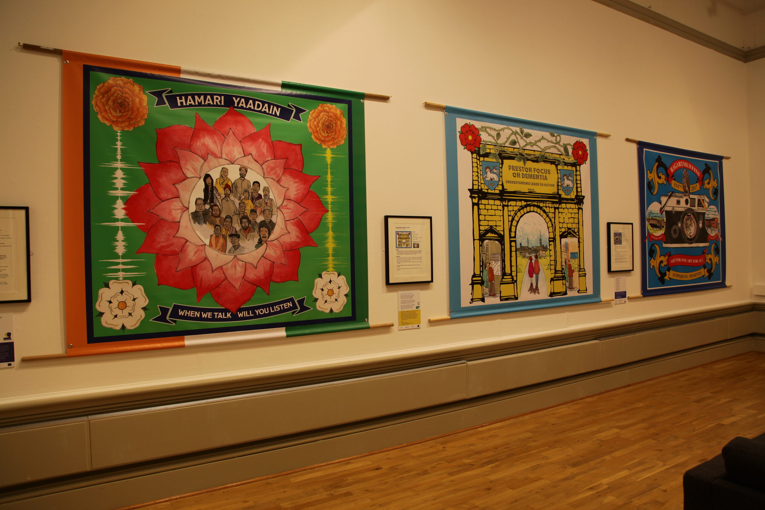 Three colourful banners hanging on a wall.