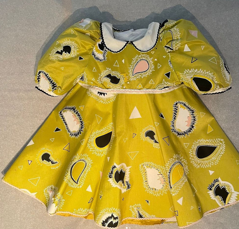 A yellow, black, pink and white baby-doll dress.