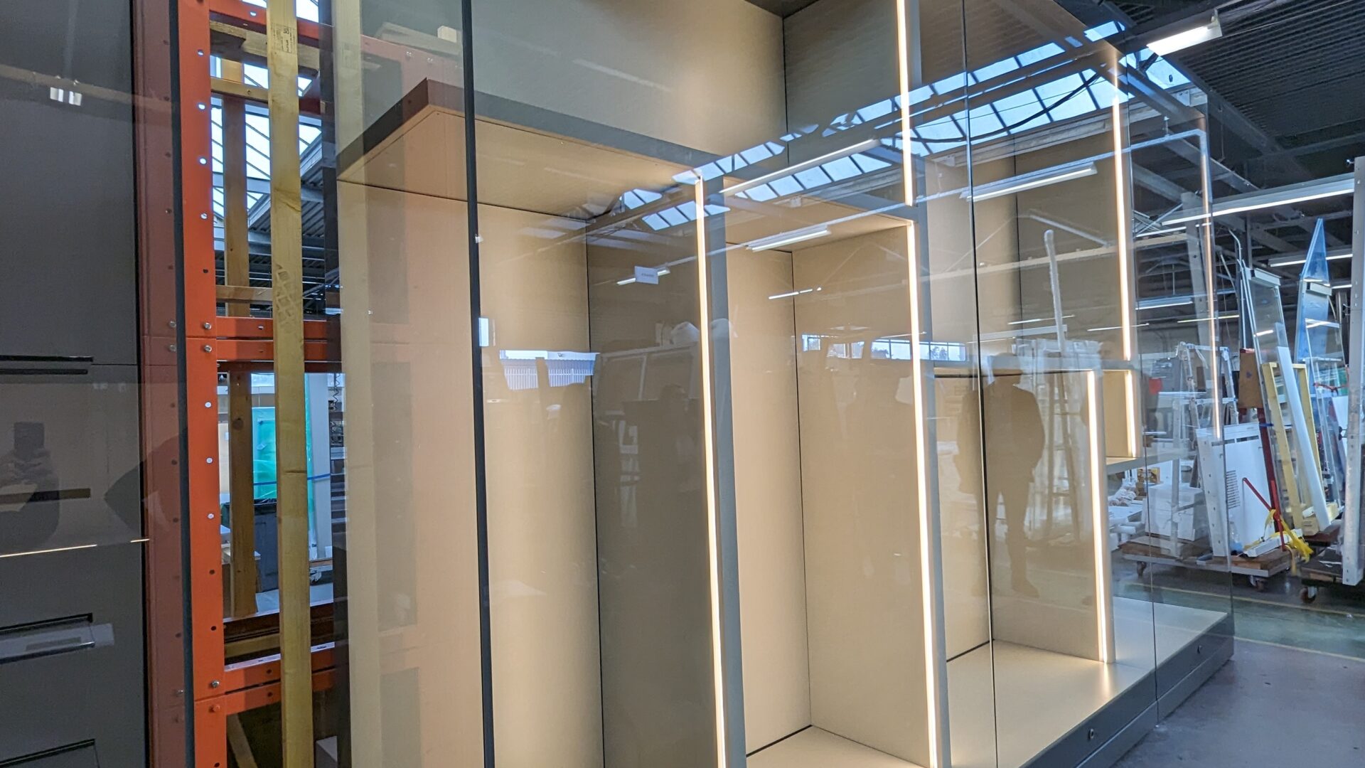 A large glass display case inside a warehouse.